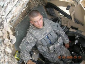 Brady Hammer, then a Private First Class, stands in the turret of a vehicle in Iraq in 2009.